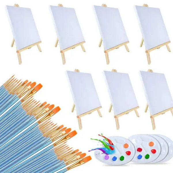 Image of the Painting Party Kit, featuring six blank canvases on wooden easels, approximately 24 blue-handled paint brushes with orange tips, and three plastic paint palettes filled with various colors—perfect for a kids party rental or an artistic slumber party.