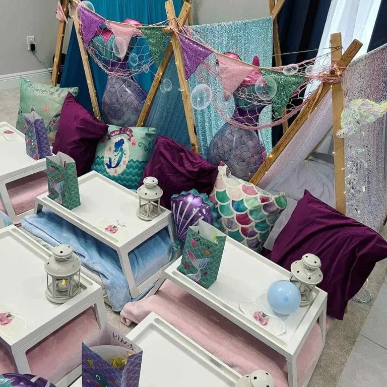 A mermaid-themed children's sleepover setup with decorated teepees, cushions, and small tables, featuring aquatic colors and patterns for the 2024 Ultimate Sleepover.