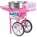 A pink Cotton Candy Machine With Dome Rental with large wheels, featuring a filled spinning bowl and two sticks with freshly made cotton candy.