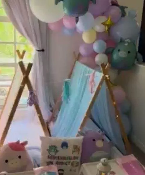 A child's room corner featuring a tent with a pastel Balloon Garland and various cute character decorations.