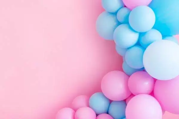 Blue and pink Jubilee balloon garland arranged on the left side of a pastel pink background, suitable for party decorations.