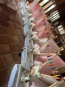 Discover a mesmerizing Cozy Boho Rainbow Party Theme with this enchanting indoor setup, perfect for capturing the vibrant essence of bohemian celebrations. Immerse yourself in the whimsical charm of small pink tents, each adorned with plush rainbow pillows and luxuriously fluffy pink blankets, meticulously aligned on a stylish tiled floor. Above, an array of eye-catching colorful triangular flags is strung gracefully across the room, enhancing the festive and inviting ambiance that ignites joy and creativity. Ideal for Pinterest inspiration or party planning enthusiasts aiming to create an unforgettable atmosphere!