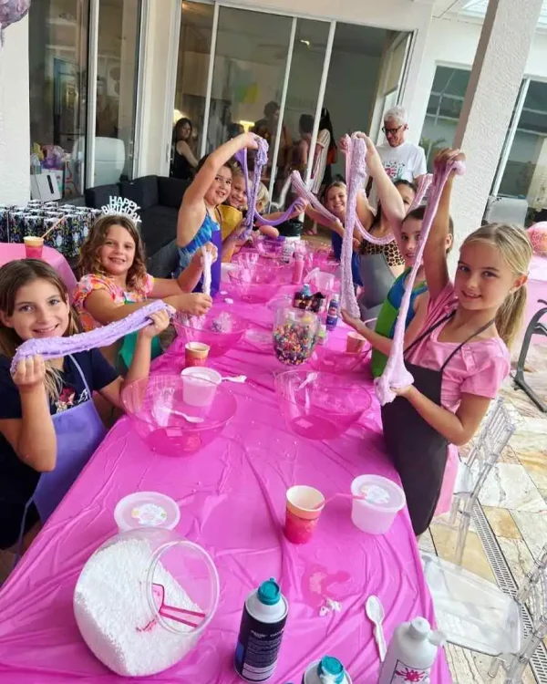 Kids making slime at a craft table during a kids party in Central Florida, with colorful craft materials and happy expressions.