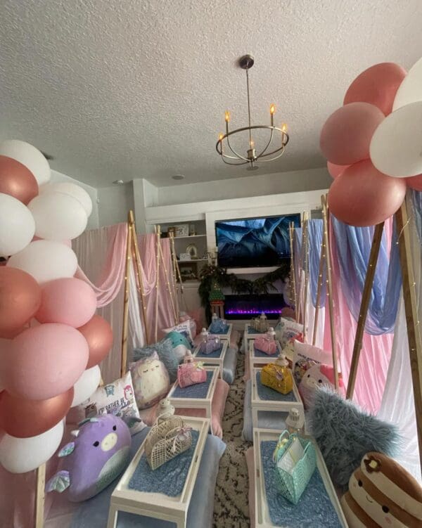Immerse yourself in the ultimate indoor camping experience with our captivating Camping Party Theme! This cozy setup features charming low tables surrounded by plush cushions, creating an inviting atmosphere perfect for social gatherings. Adorned with vibrant pink and white balloons, the room bursts with playful colors that delight the senses. An enchanting ice scene displayed on a large TV screen enhances this whimsical theme, transporting guests to an adventurous winter wonderland. Scattered decorative baskets and cuddly plush toys add layers of texture and intrigue, amplifying the sense of adventure and discovery. Ideal for those seeking a unique entertainment option or hosting a themed event, this camping ambiance promises to captivate hearts and ignite imaginations. Optimize your festive celebrations with this creatively designed space that cleverly combines comfort, style, and adventure in one delightful package!.