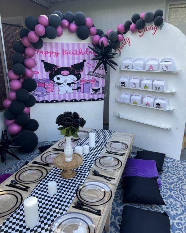 Outdoor birthday party setup with a pink and black "kuromi" theme, featuring a decorated seating area, balloons, and a backdrop with personalized signs for the 2024 Ultimate Sleepover.