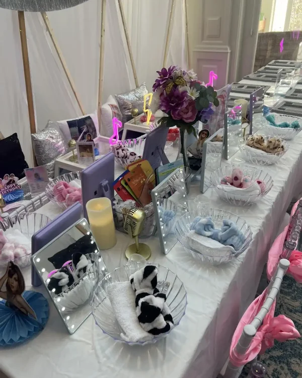 Transform your spa party into a stunning display with mirrors, LED lights, bowls filled with towels and hairbands, and vibrant party decorations featuring flowers and music note symbols. Ideal for hosting a Spa Party with the exciting DIY Lip Gloss station!