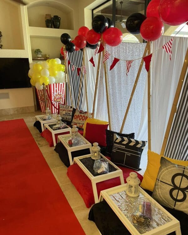 Create the ultimate Movie Night Extravaganza in your home with our stunning indoor setup. Walk the glamorous red carpet and immerse yourself in a cinematic experience complete with film-themed pillows that add charm to any space. Savor delicious popcorn from stylish bags as vibrant balloons in bold shades of red, yellow, and black dance against an elegant white backdrop. Perfect for film enthusiasts seeking a unique and immersive movie night decor!