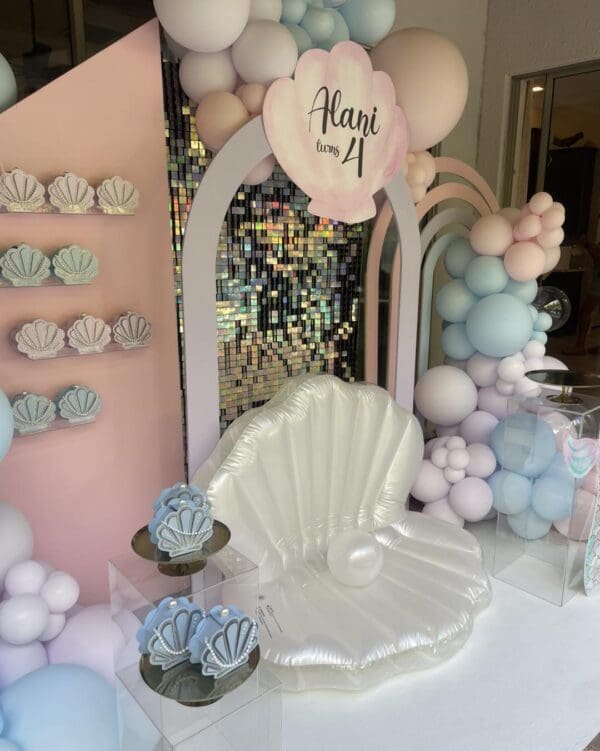 Celebrate Alani's 4th birthday in whimsical style with our enchanting "Pearls, Seashells, and Movie Night Extravaganza" theme. Imagine vibrant pastel balloons dancing in the breeze, creating a dreamy atmosphere for an unforgettable outdoor movie screening under the starlit sky. The scene is set with an elegantly adorned decorative chair amidst shimmering pearls and seashells, promising a magical experience that blends seaside charm with cinematic wonder. Perfect for family gatherings and memory-making moments!