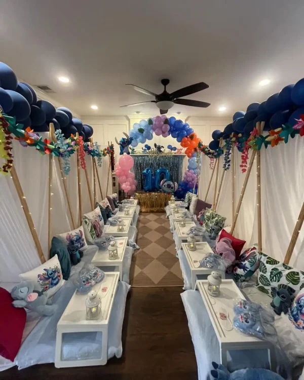 A room is decorated for a Harry Potter Themed Party with tents, pillows, and lanterns lining both sides. A balloon arch and "10" balloon display are visible at the end of the room, creating a magical atmosphere.