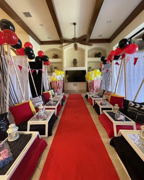 Step into a Hollywood-inspired movie-themed party room, lavishly decorated to transport you straight to the glitz and glamour of the silver screen. A plush red carpet welcomes guests in true celebrity style, setting the scene for an unforgettable cinematic experience. Eye-catching black and red balloons float above, adding pops of drama and excitement throughout the space. Cozy up with an array of decorative movie-themed pillows featuring iconic film reels, clapperboards, and popcorn motifs—perfect for creating that ultimate blockbuster ambiance. Ideal for any film fanatic or those looking to host an Oscar-worthy celebration!