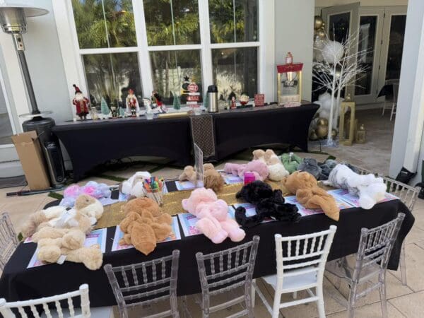 The outdoor venue is transformed into a whimsical wonderland, featuring tables elegantly decorated with plush teddy bears and vibrant children's activity sets that spark imagination and joy. Nearby, a captivating Movie Concession Stand Rental brimming with eye-catching decorations and state-of-the-art machines elevates the celebratory atmosphere. Discover how these enchanting elements combine to craft an unforgettable party experience for kids and families alike.