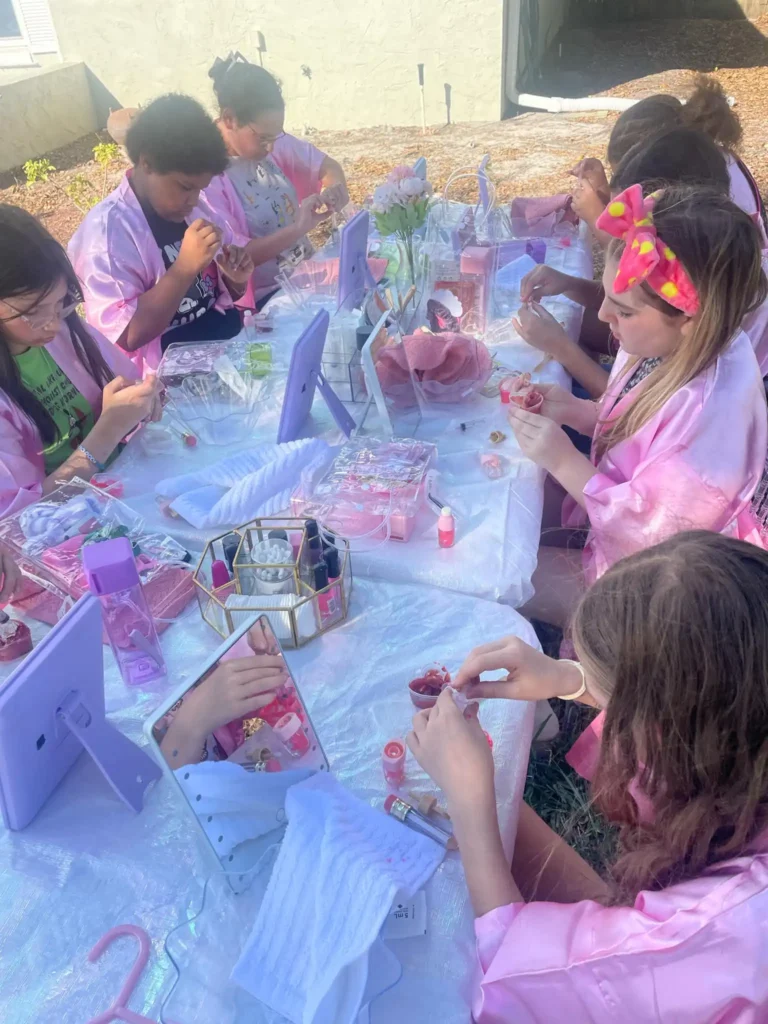 In a vibrant, lively atmosphere, children dressed in adorable pink robes gather around a stylish table adorned with makeup kits and handheld mirrors. Immersed in their own captivating mobile slime party experience, they skillfully combine beauty activities with the enchanting fun of DIY slimy creations. The air buzzes with excitement as these young artists embrace the colorful chaos, ensuring everyone relishes this delightful fusion of glamour and creativity at the ultimate slime-themed celebration. Perfect for any child’s memorable event, this unique blend of imaginative play and cosmetic exploration is sure to be a hit!